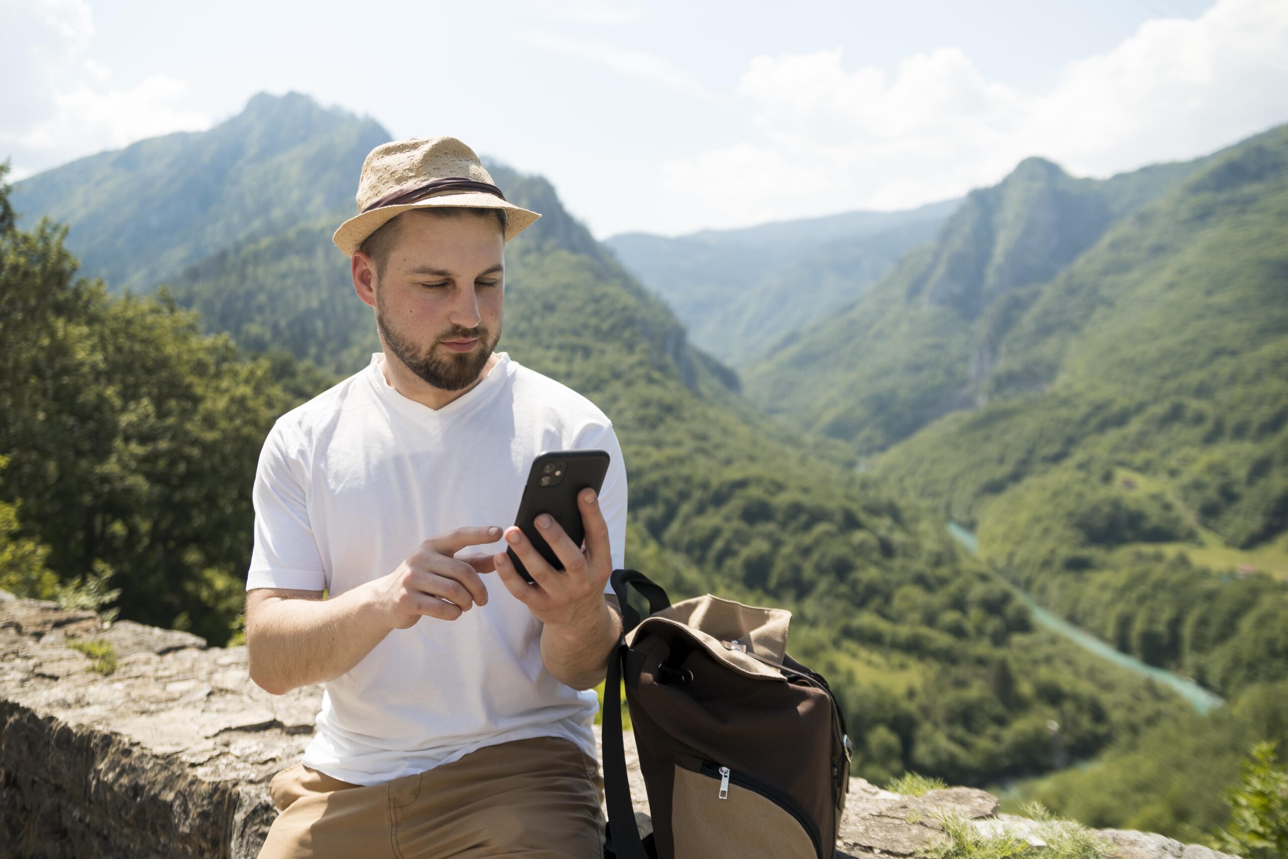 Ein Mann, der auf seinem Smartphone mit eSIM nach Online-Casinos sucht, während er auf dem Land unterwegs ist.